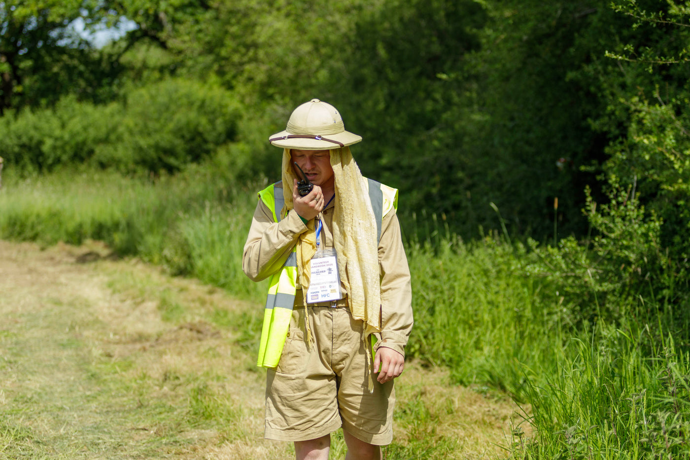 An Overlord Show steward in period tropical kit using a radio on the showground