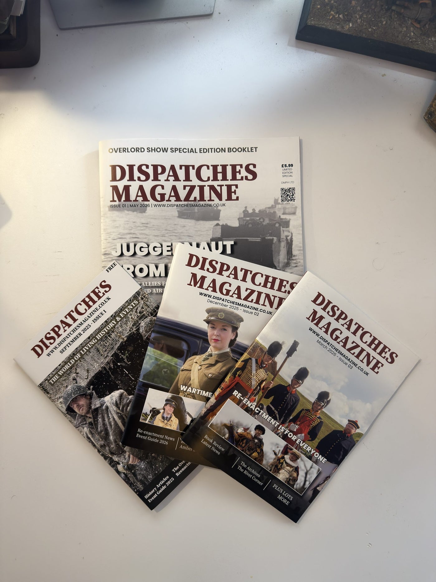 Several issues of Dispatches Magazine laid out on a table